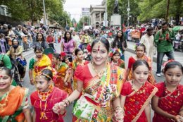 People dressed in traditional Indian clothing march in a parade.